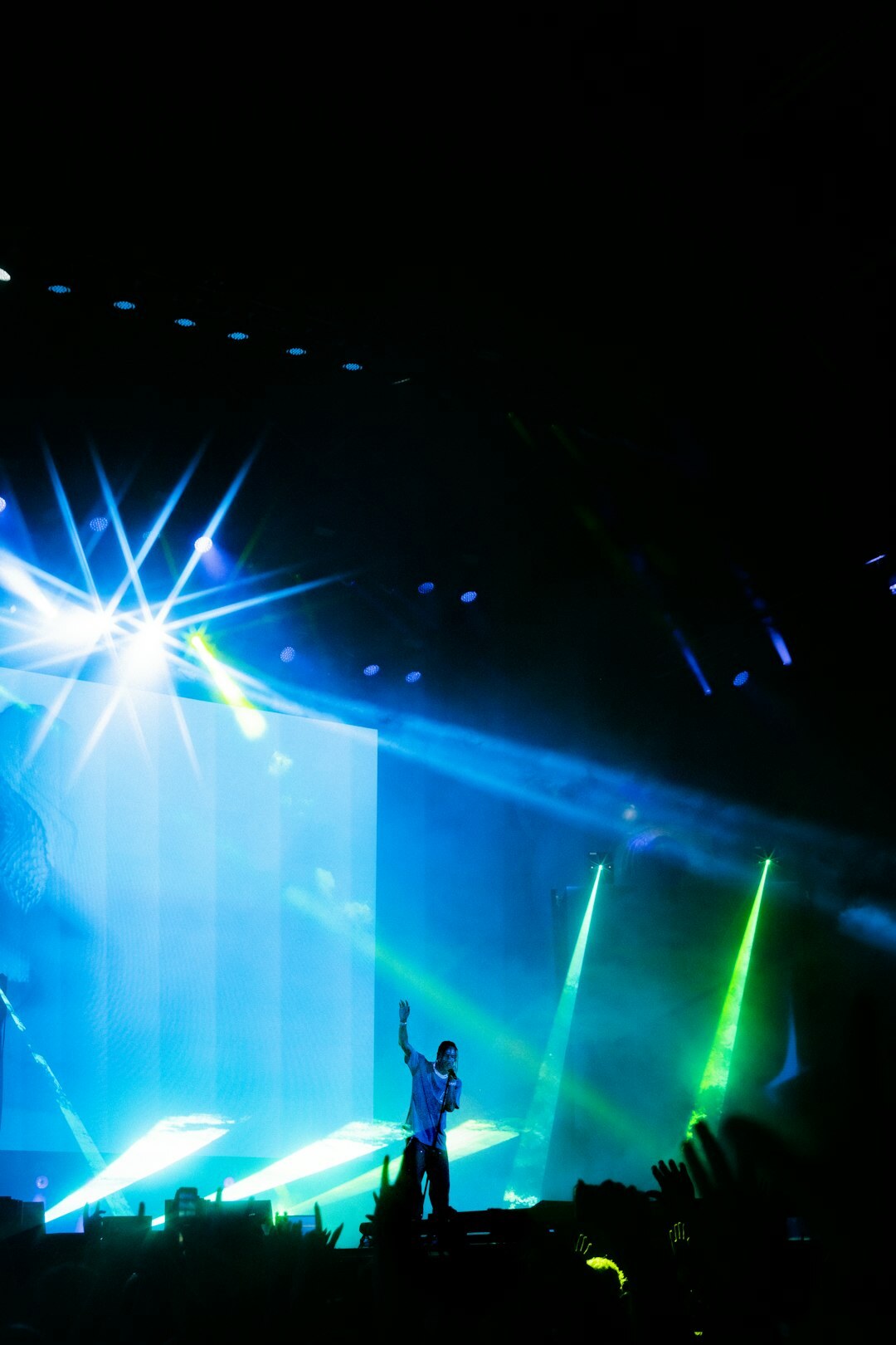 Live concert stage with colorful lights and performer silhouette