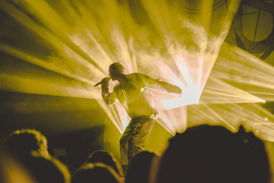 Singer performing into a microphone under stage light