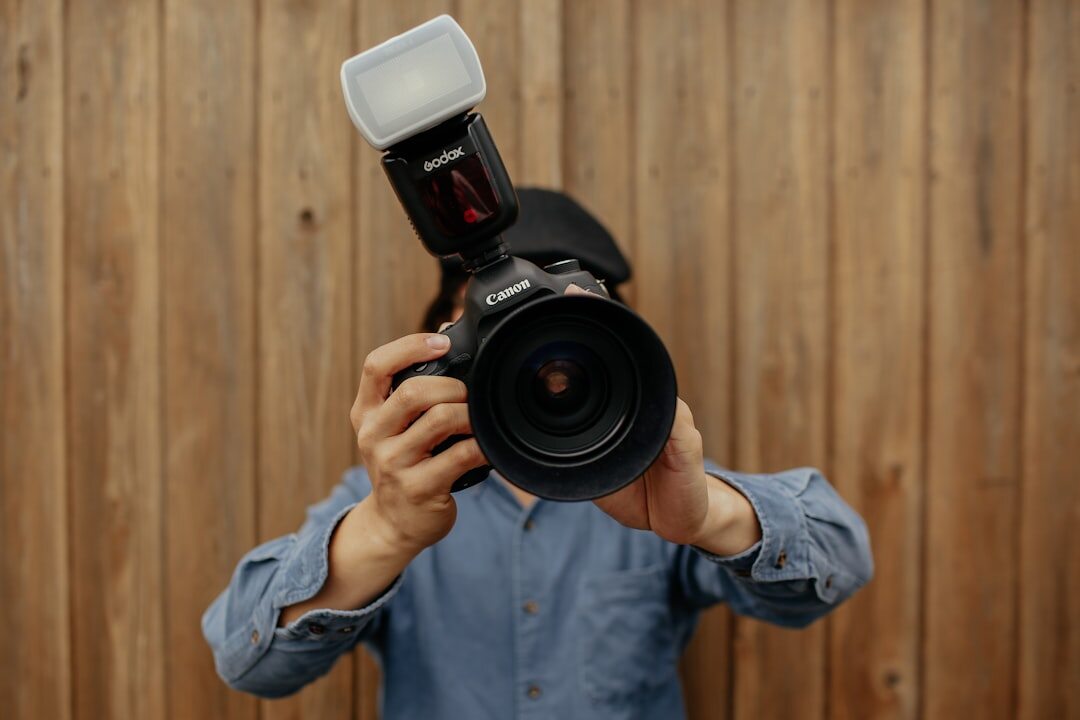 Photographer holding a professional camera with flash